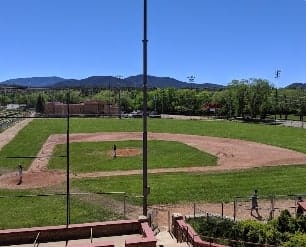 Sandia Hearing Aids Santa Fe - A view of a baseball field with mountains in the background.