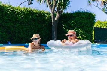 Sandia Hearing Aids Santa Fe - Two people relaxing in a swimming pool.