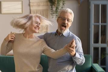 Sandia Hearing Aids Santa Fe - An older couple dancing in their living room.